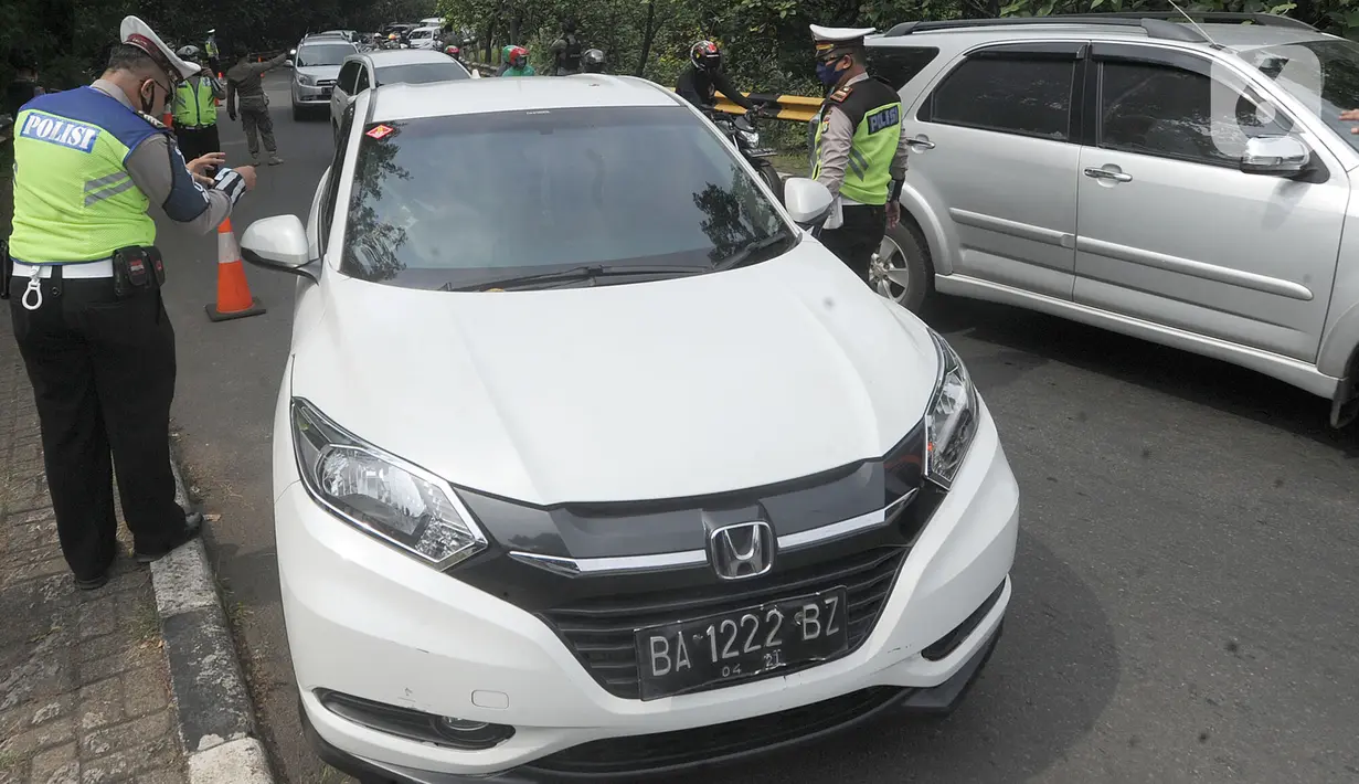 Petugas memeriksa KTP pengendara berplat daerah saat penyekatan kendaraan menuju Jakarta di Kelapa Dua, Jagakarsa, Jakarta Selatan, Rabu (27/05/2020). Masyarakat yang akan memasuki Jakarta wajib mempunyai Surat Izin Keluar Masuk (SIKM), jika tidak akan diminta putar balik. (merdeka.com/Arie Basuki)