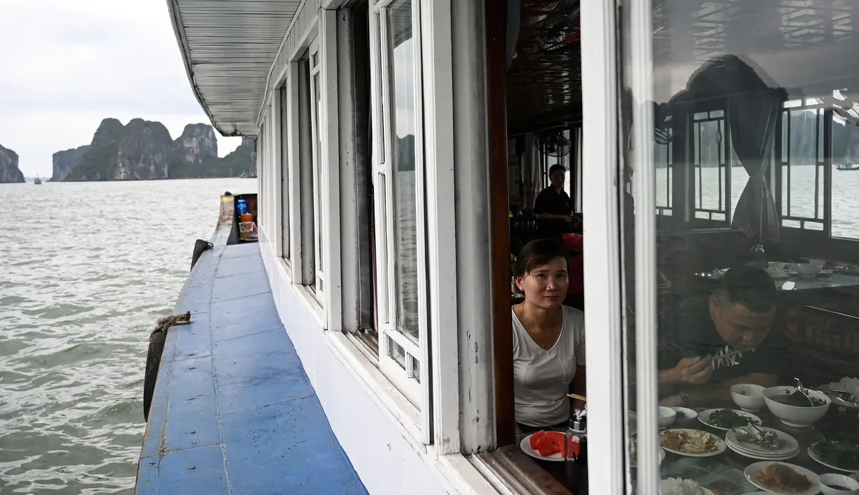 Wisatawan domestik menikmati makan siang di atas kapal di kawasan Ha Long Bay, Quang Ninh, Vietnam, (16/5/2020). Seiring dengan meredanya virus corona, Ha Long Bay kawasan yang menjadi situs warisan dunia UNESCO kembali didatangi ratusan wisatawan. (AFP/Manan Vatsyayana)