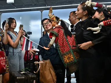 Turis China disambut oleh penari di gerbang kedatangan Bandara Internasional Suvarnabhumi, Bangkok, Thailand, Senin (25/9/2023). Turis China yang mendarat di Bangkok disambut bak tamu VIP. (Lillian SUWANRUMPHA/AFP)