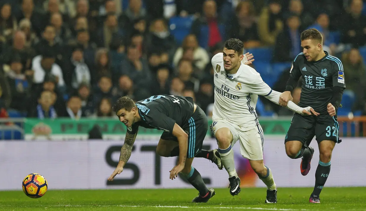 Pemain Real Madrid, Mateo Kovacic (tengah) berusaha melewati dua pemain Real Sociedad pada laga La Lga Spanyol di Santiago Bernabeu stadium, Madrid (29/1/2017). Madrid menang 3-0. (AP/Francisco Seco)