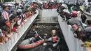 Warga dan pengendara berkerumun melihat upaya tim gabungan melakukan pencarian buaya di Kali Grogol, Jakarta Barat, Kamis (28/6). Pencarian telah dilakukan sejak kemarin siang ketika warga melaporkan penampakan buaya itu. (Merdeka.com/Iqbal S. Nugroho)
