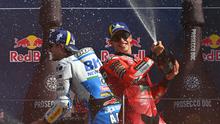 Alex Marquez (Kiri) dan Marc Marquez merayakan sukses naik podium MotoGP Catalunya 2025. (Andreas SOLARO / AFP)