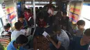 Anak-anak Afghanistan membaca buku dalam bus yang dijadikan perpustakaan keliling di Kabul, 4 April 2018. Bus keliling itu digunakan sebanyak 300 anak setiap hari dengan menggunakan kendaraan yang disewa dari perusahaan bus milik negara. (AFP/Shah MARAI)