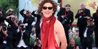 Timothee Chalamet tampil berani di red carpet dengan outfit serba merah. Ia mengenakan busana rancangan Haider Ackermann. Foto: Vogue.