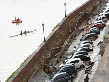 Puluhan mobil terpelosok saat parkir di pinggir sungai Arno yang tiba-tiba amblas di Lungarno Torrigiani, Florence, Italia (25/5). Menurut petugas, kejadian tersebut disebabkan oleh pecahnya pipa besar saluran air. (AFP PHOTO/CLAUDIO GIOVANNINI)