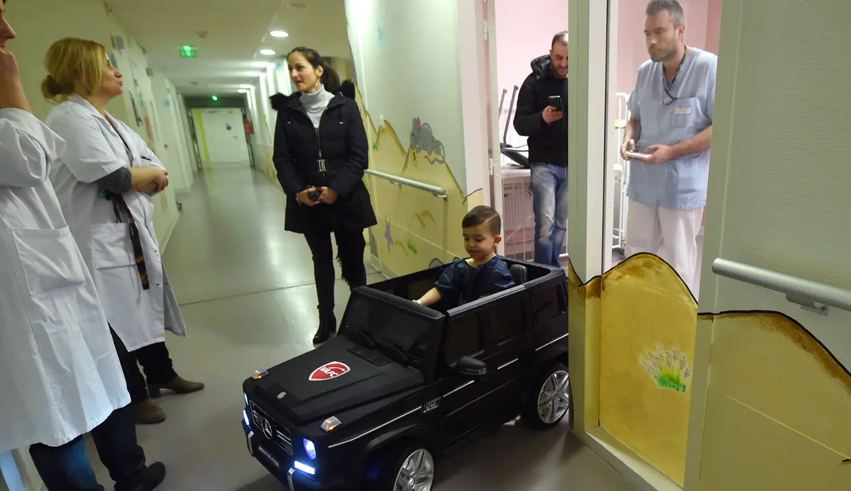 Souvail (2) mengendarai mobil mainan listrik menuju ruang operasi di Rumah Sakit Valenciennes, Prancis, Jumat (2/2). Rumah sakit ini memiliki tiga mobil mainan yang salah satunya sumbangan dari Valenciennes Football Club. (FRANCOIS LO PRESTI/AFP)