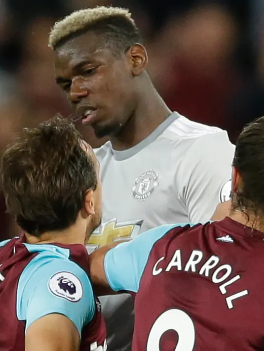 Pemain West Ham United Mark Noble (kiri) terilbat bentrok dengan pemain Manchester United Paul Pogba usai terjadi pelanggaran saat pertandingan Liga Inggris di London Stadium di London (10/5). (AP Photo / Alastair Grant)
