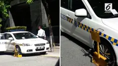 Petugas kepolisian Malaysia melanggar aturan lalu lintas karena parkir mobil patroli sembarangan.