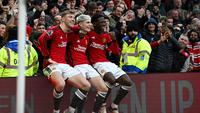 Tiga pemain Manchester United, Rasmus Hojlund, Alejandro Garnacho, dan Kobbie Mainoo duduk di atas papan iklan lapangan Old Trafford sebagai bentuk selebrasi gol yang dicetak ke gawang West Ham United dalam laga pekan ke-23 Premier League 2023/2024, Minggu (4/2/2024) malam WIB. (Paul ELLIS / AFP)