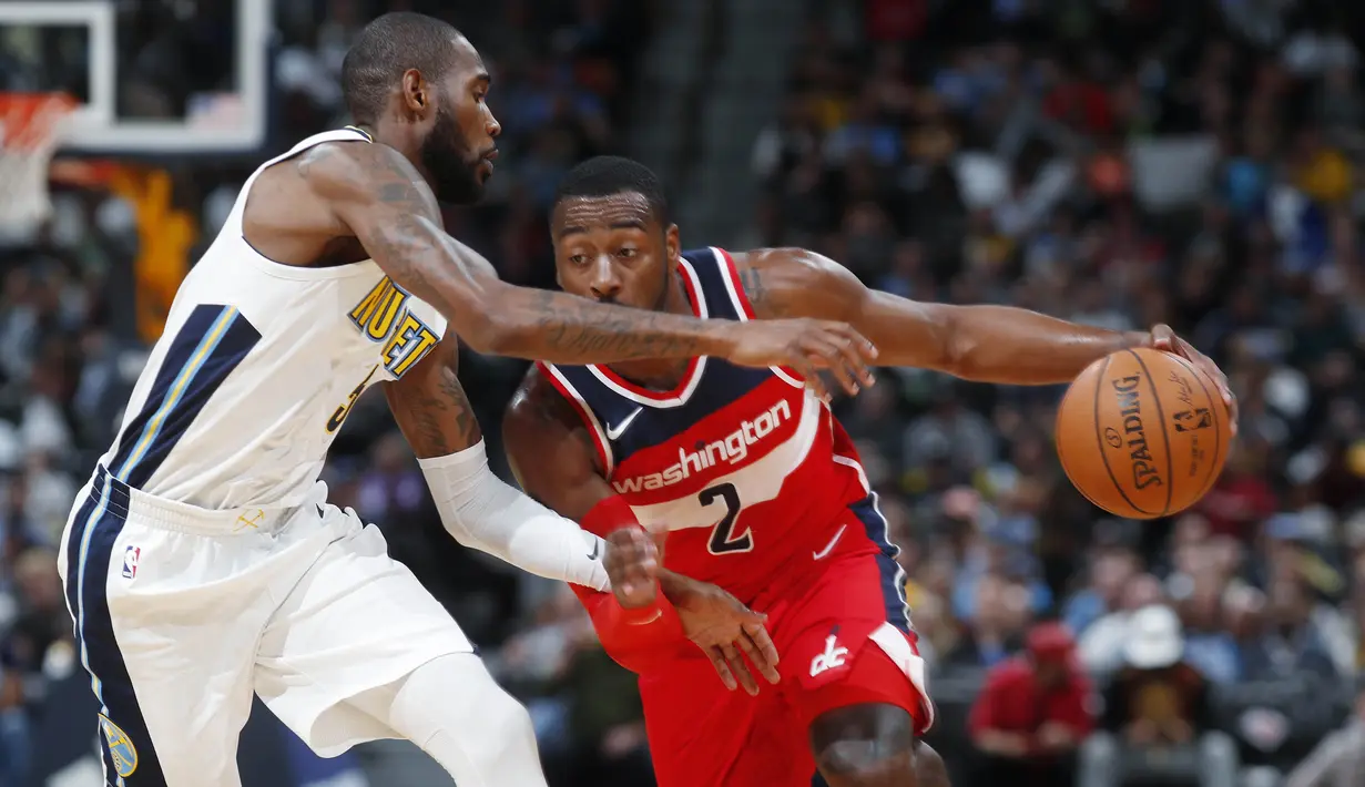 Pebasket Washington Wizards, John Wall, berusaha melewati pebasket Denver Nuggets, Will Barton, pada laga NBA di Pepsi Center, Denver, Selasa (23/10/2017). Denver Nuggets kalah 104-109 dari Washington Wizards. (AP/David Zalubowski)