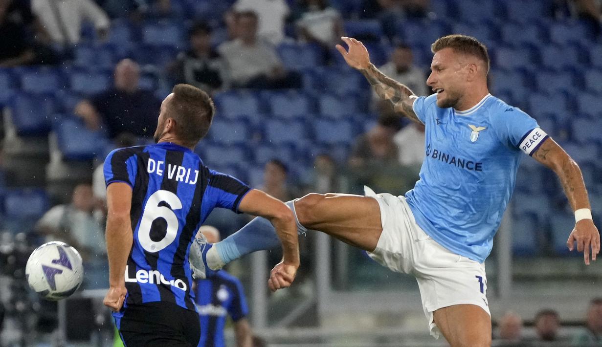 Penyerang Lazio Ciro Immobile berebut bola dengan bek Inter Milan Stefan de Vrij pada pekan ketiga Serie A 2022/2023 di Stadio Olimpico, Roma, Sabtu (27/8/2022) dini hari WIB. Lazio mampu memberikan kekalahan perdana untuk Inter Milan usai menang 3-1. (AP Photo/Gregorio Borgia)