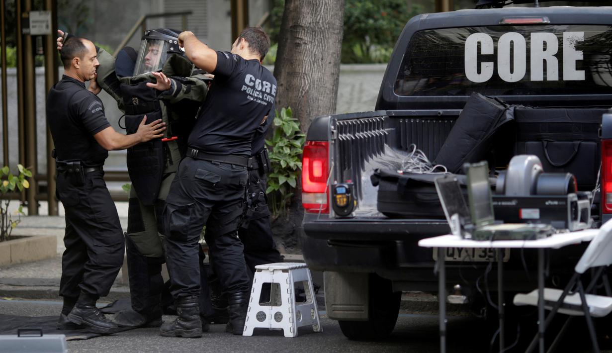 Petugas Penjinak Bahan Peledak dari Kepolisian Brasil menggunakan pakaian khusus sebelum menghampiri tas mencurigakan di Rio de Janeiro, Senin (18/7). Pemerintah Brasil memperketat keamanan jelang Olimpiade Rio de Janiero 2016. (REUTERS/Ricardo Moraes)
