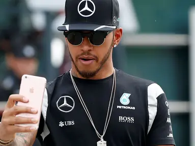 Pembalap F1 dari tim  Mercedes, Lewis Hamilton berselfie di sirkuit Internasional Shanghai untuk memulai grand prix Cina, (14/4/16). Lewis Hamilton adalah pembalap pertama Formula 1 yang berkulit gelap. (REUTERS/Aly Song)