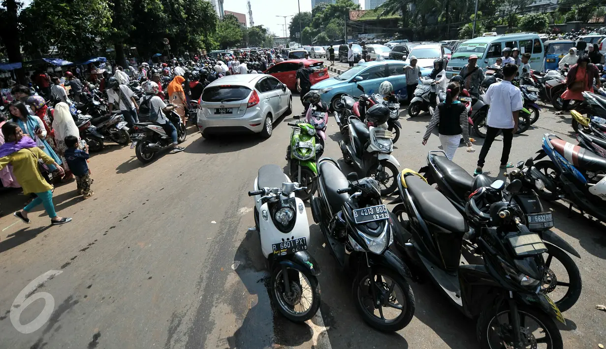 Kendaraan milik peziarah diparkir hingga memenuhi badan jalan depan TPU Karet Bivak, Jakarta, Rabu (6/7). Padatnya peziarah menyebabkan arus lalin di depan TPU menjadi tersendat karena warga memarkir kendaraan di badan jalan. (Liputan6.com/Yoppy Renato)