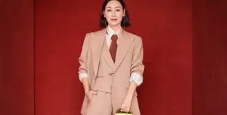 Hui Yinghong tampil dengan mengenakan setelan jas tiga potong, kemeja crepe sutra merah muda, dasi cokelat, sepatu hak tinggi kulit hitam, dan tas Gucci Diana. Sumber: Document/Gucci.