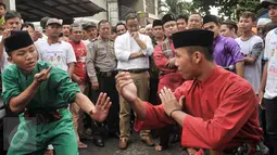 Cagub DKI Jakarta, Anies Baswedan menyaksikan seni silat tradional Betawi 'palang Pintu' saat mengunjungi kawasan Menteng Dalam, Jakarta, Kamis (2/2). (Liputan6.com/Yoppy Renato)