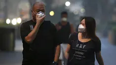 Sejumlah warga memakai masker saat berjalan di pusat perbelanjaan Orchard Road, Singapura (25/9/2015). Menurut Badan Lingkungan Nasional Singapura kabut Polutan Standar Indeks (PSI) mencapai tinggi 341 pada hari Jumat. (REUTERS/Edgar Su)