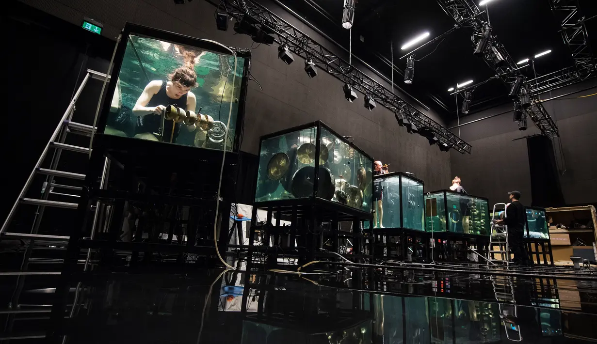Konser Underwater AquaSonic menghadirkan lima pemain yang menenggelamkan diri mereka di tangki air kaca untuk memainkan instrumen buatan sendiri dan bernyanyi sepenuhnya di bawah air di Aarhus, Denmark, Rabu (19/4). (AFP PHOTO / Jonathan NACKSTRAND)