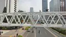Pengendara melintas di bawah Jembatan Penyebrangan Orang (JPO) Dukuh Atas, Jakarta, Rabu (3/10). Rencananya Pemprov DKI Jakarta akan merelokasi JPO Dukuh Atas namun belum dapat dipastikan kapan dilaksanakan. (Liputan6.com/Herman Zakharia)