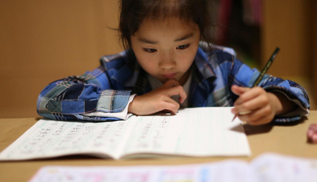 Mahiro Takano ketika mengerjakan tugas sekolah di rumahnya di Nagaoka, Niigata, Jepang, 18 November 2015. Saat usianya mencapai 9 tahun, ia berhasil  memenangkan All Japan Karatedo SMP Championships selama  tiga tahun berturut-turut. (dailymail.co.uk)