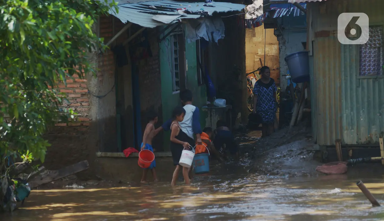 Warga membersihkan rumah dari sisa lumpur  di Bukit Duri, Jakarta, Jumat (29/10/2021). Hujan dengan intensitas tinggi beberapa hari lalu membuat aliran sungai ciliwung meluap yang merendam sebagian rumah warga yang tinggal di bantaransungai  tersebut. (merdeka.com/Imam Buhori)