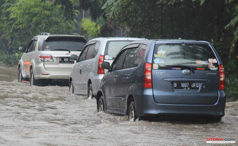 Sejumlah mobil berjalan perlahan saat melewati banjir