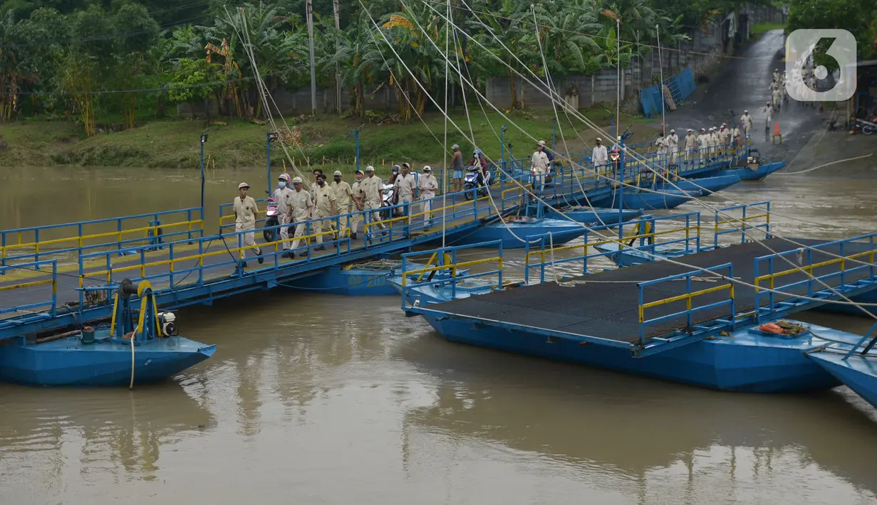 Pejalan kaki dan pengendara sepeda motor melintasi jembatan perahu di atas Sungai Citarum, Karawang, Jawa Barat, Sabtu (20/11/2021). Jembatan perahu ini menjadi jalan alternatif yang menghubungkan antara Desa Anggadita dengan Kawasan Pabrik Dusun Rumambe 1. (merdeka.com/Imam Buhori)