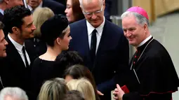 Katy Perry bersama Orlando Bloom berbincang dengan Sekretaris Dewan Kepausan untuk Kebudayaan uskup Paul Tighe pada akhir audiensi oleh Paus Francis di aula Paul VI, Vatikan, (28/4). (AP Photo / Alessandra Tarantino)