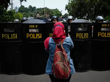 Seorang mahasiswa mengabadikan penjagaan kepolisian saat aksi demonstrasi di Istana Negara, Jakarta, Kamis (20/10). Aksi yang dilakukan mahasiswa merupakan peringatan tepat dua tahun pemerintahan Joko Widodo-Jusuf Kalla. (Liputan6.com/Faizal Fanani)
