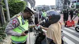 Petugas polisi mengecek dokumen pengendara saat penyekatan ruas Jalan Simatupang mengarah ke Fatmawati, Jakarta, Sabtu (10/7/2021). Penambahan titik penyekatan jalan untuk mempertegas bahwa Jakarta masih masa PPKM Darurat. (Liputan6.com/Faizal Fanani)