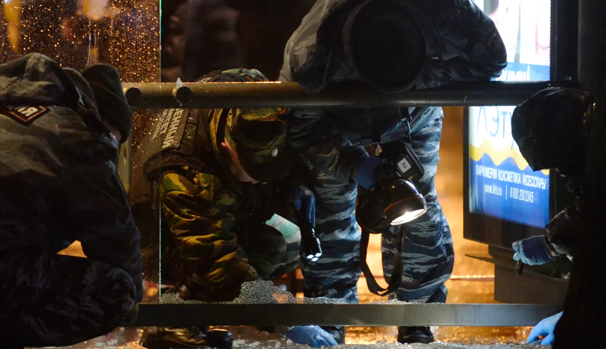 Polisi memeriksa sebuah halte bus yang rusak akibat terkena ledakan di Moskow, Rusia, Senin (7/12). Tiga orang luka terkena pecahan kaca. Bahan peledak diperkirakan dilemparkan dari mobil atau bangunan perumahan di dekatnya. (AFP/NATALIA Kolesnikova)