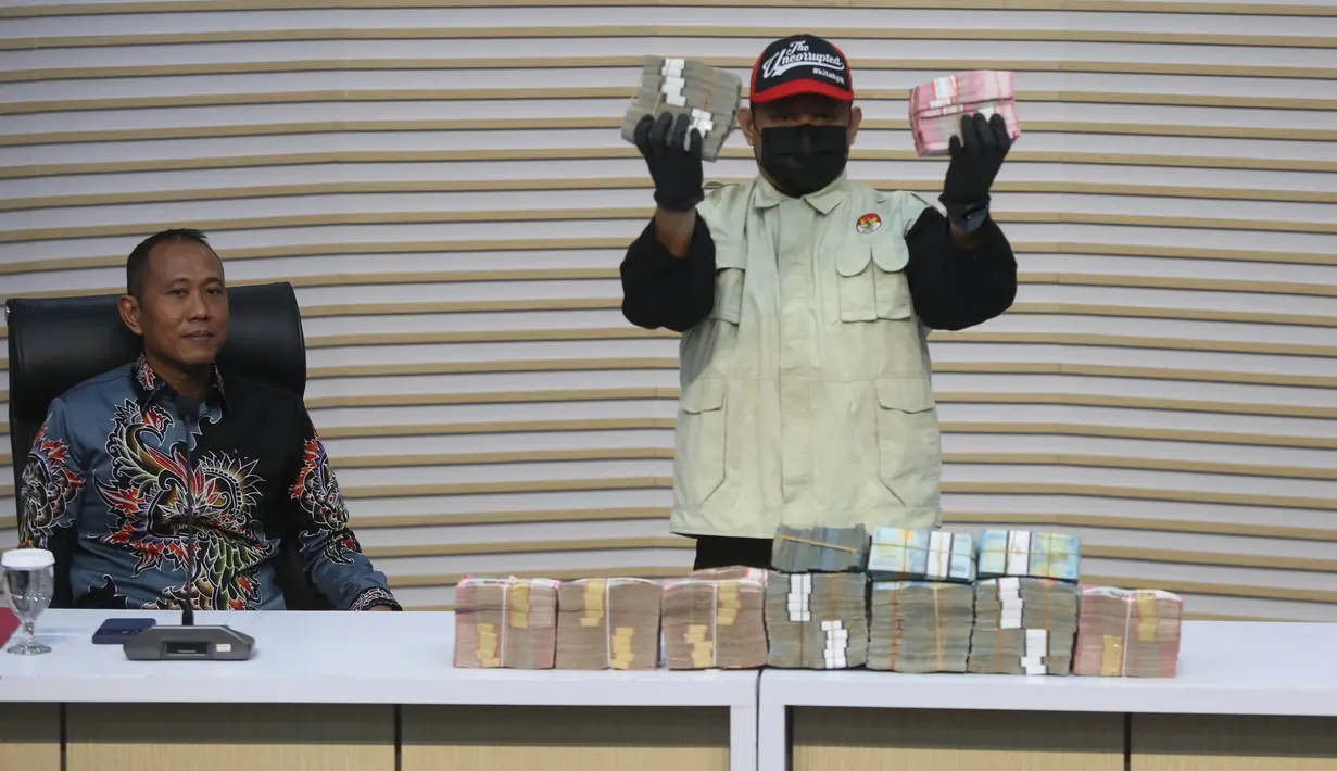 Petugas menunjukkan barang bukti uang hasil OTT Bupati Lombok Barat Lalu Ahmad Zaini di Gedung Merah Putih KPK, Jakarta, Selasa (21/7/2026). (KLY/Arie Basuki)