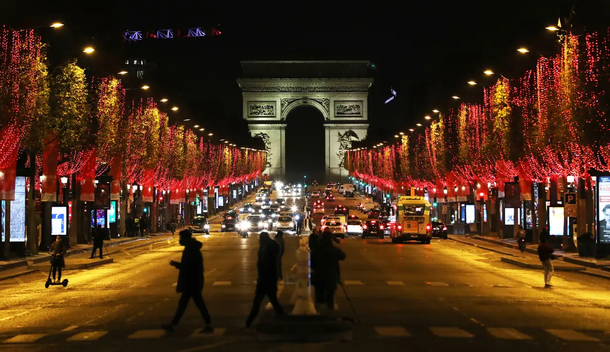 Champs-Elysees Avenue dan Arc de Triomphe tampak terang usai lampu Natal dinyalakan di Paris, Prancis, pada 22 November 2020. Upacara penyalaan lampu digelar pada Minggu (22/11), tetapi penonton tidak diizinkan datang ke lokasi lantaran diberlakukannya kebijakan lockdown COVID-19. (Xinhua/Gao Jing)