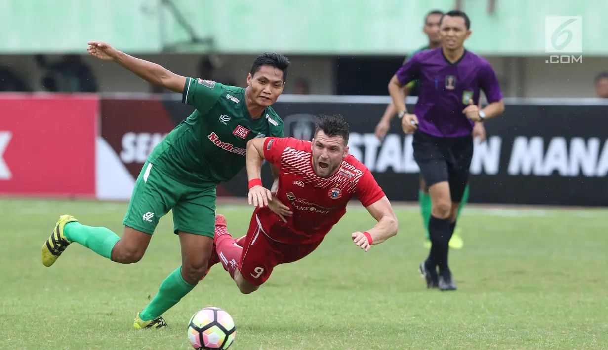 Pemain depan Persija, Marko Simic terjatuh saat berebut bola dengan pemain PSMS pada laga kedua Semifinal Piala Presiden 2018 di Stadion Manahan, Solo, Jawa Tengah, Senin (12/2). Persija unggul 1-0. (Liputan6.com/Helmi Fithriansyah)