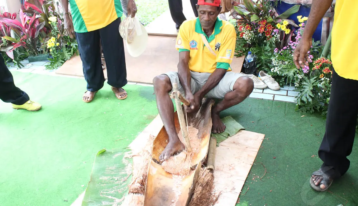 Salah seorang dari Sorong Selatan tampak sedang memukul batang sagu yang telah dipotong dengan kayu yang dibentuk segitiga, pengolahan tradisional ini disebut dengan Nani, Senayan, Jakarta. (3/5/2014) (Liputan6.com/Gilar Dhani)