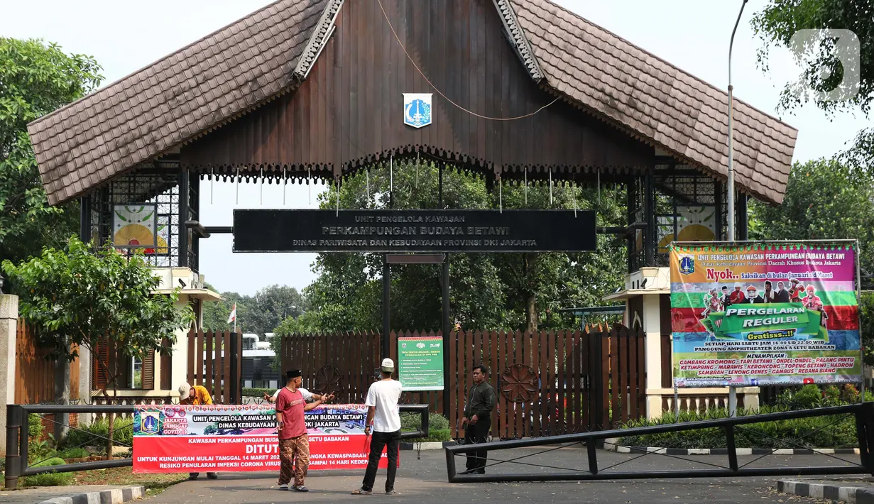 Petugas pengelola memasang spanduk pemberitahuan penutupan Kawasan Wisata Perkampungan Budaya Betawi Setu Babakan, Jakarta, Sabtu (14/3/2020). Hal ini menyusul instruksi Gubernur DKI Jakarta yang menutup sejumlah lokasi wisata selama 14 hari kedepan. (Liputan6.com/Helmi Fithriansyah)