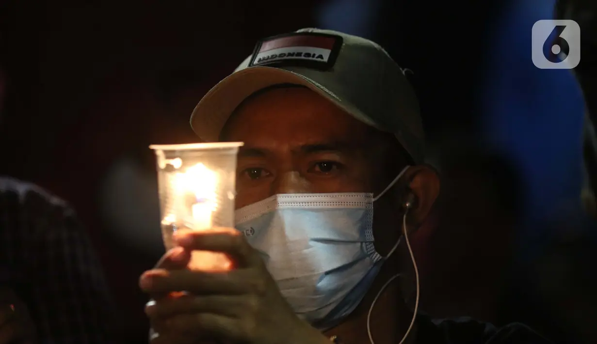 Peserta aksi unjuk rasa memegang lilin saat doa bersama lintas agama di Kawasan Patung Kuda, Jakarta, Selasa (10/11/2020). Sejumlah massa gabungan dari berbagai organisasi buruh dan mahasiswa berunjuk rasa menolak pengesahan Omnibus Law UU Cipta Kerja. (Liputan6.com/Helmi Fithriansyah)