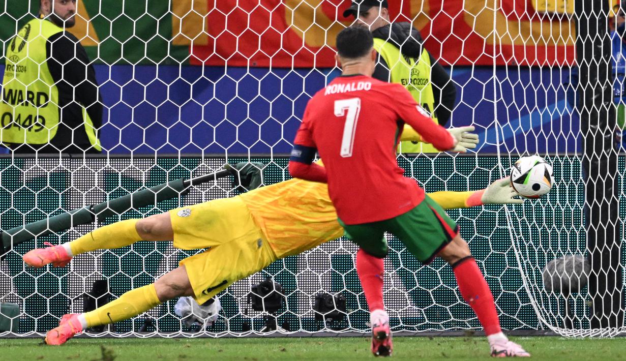 Pemain Portugal, Crsitiano Ronaldo, gagal mencetak gol penalti setelah berhasil dihalau kiper Slovenia, Jan Oblak pada babak 16 besar Euro 2024 di Frankfurt Arena, Selasa (2/7/2024). (AFP/Kirill Kudryavtsev)