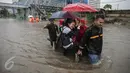 Sejumlah orang memanfaatkan jasa gerobak untuk menyeberangi banjir yang merendam Jalan Gunung Sahari, Jakarta Pusat, Selasa (21/2). Hujan deras yang mengguyur sejak Selasa dini hari membuat sebagian wilayah di Jakarta banjir. (Liputan6.com/Faizal Fanani)