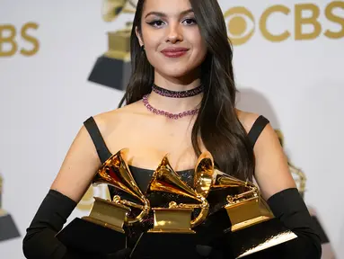 Olivia Rodrigo berpose dengan piala penghargaan Best Pop Vocal Album, Best New Artist, dan Best Pop Solo Performance pada ajang Grammy Awards 2022 di MGM Grand Garden Arena, Las Vegas, Amerika Serikat, 3 April 2022. (AP Photo/John Locher)