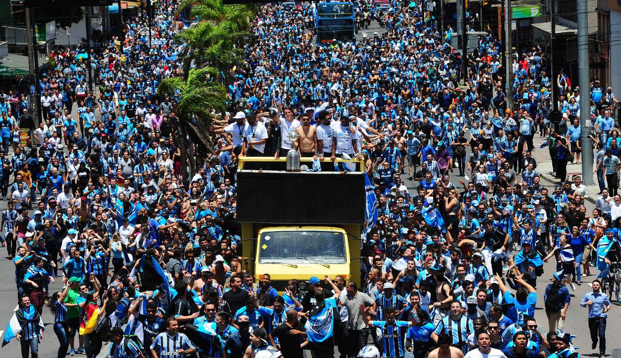 Pemain dan suporter Gremio merayakan keberhasilan meraih juara Copa Libertadores dengan pawai di Porto Alegre, Brasil, Kamis (30/11/2017). Gremio menjadi juara Copa Libertadores setelah mengalahkan Lanus dengan skor agregat 3-1. (AFP/Itamar Aguiar)