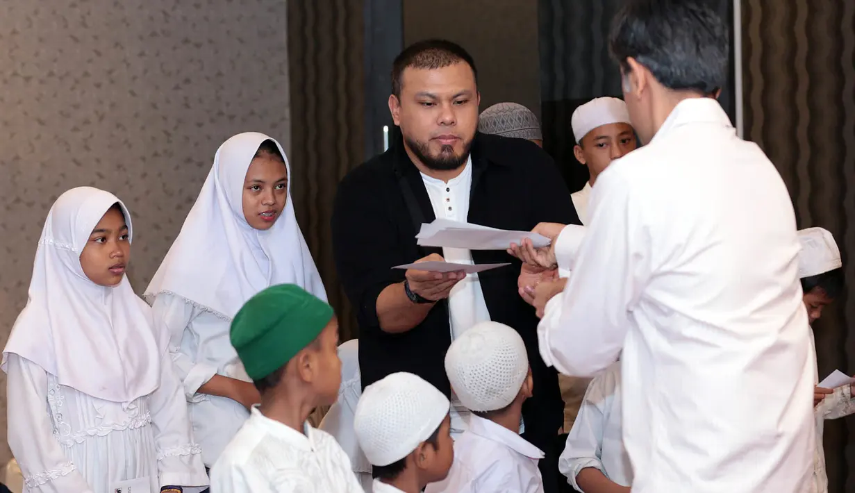 Penulis skenario dan sutradara Joko Anwar membagikan amplop kepada anak yatim yang hadir dalam syukuran film terbarunya. Menurutnya, saat membuat film, ia sama sekali tidak memikirkan target penonton. (Deki Prayoga/Bintang.com)