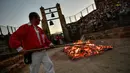 Seorang pria menyiapkan kayu bakar sebelum perayaan malam San Juan di San Pedro Manrique, Spanyol Utara, Minggu (24/6). Tradisi kuno Spanyol ini diperingati untuk menyambut musim panas. (AP Photo/Alvaro Barrientos)
