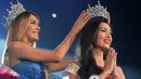 Miss International Queen 2014 , Isabella Satiago memasangkan mahkota kepada kontestan dari Filipina Trixie Maristela usai dinobatkan sebagai pemenang Miss International Queen 2015 di Pattaya, Thailand, Jumat (6/11). (AFP Photo/Pornchai Kittiwongsakul)