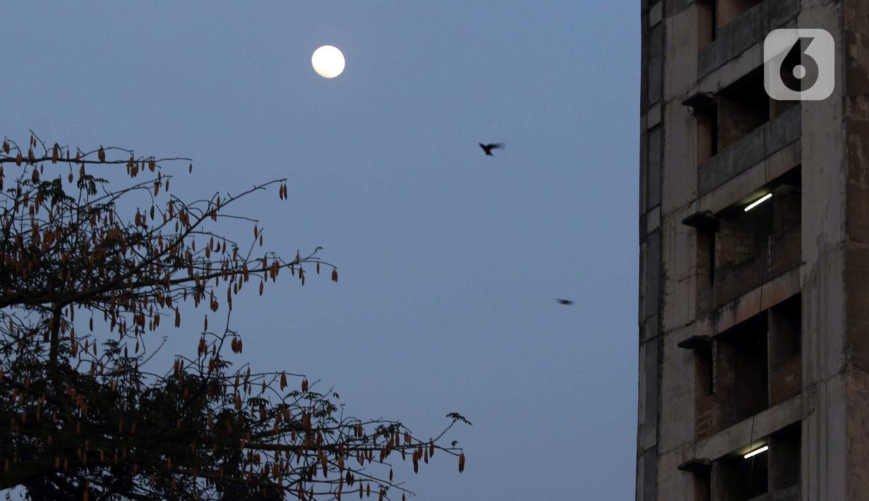 Pemandangan bulan dan bangunan rusun yang menjadi lokasi syuting film Pengabdi Setan 2: Communion di kawasan Bekasi, Jawa Barat, Rabu (10/8/2022). Pada mulanya, rusun tersebut merupakan program bersubsidi untuk masyarakat berpenghasilan rendah. (Liputan6.com/Herman Zakharia)