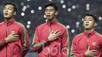 Kiper Timnas Indonesia U-22, Satria Tama (tengah), bernyanyi lantang saat lagu Indonesia Raya berkumandang sebelum uji coba melawan Persija. Kesempatan bermain untuk Merah Putih memberikan kebanggaan bagi mereka. (Bola.com/Vitalis Yogi Trisna) 