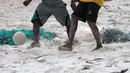 Kaki-kaki pemuda pemuda desa berebut bola saat bermain bola dekat pantai di Desa Matwaer, Kei Kecil, Maluku (25/12/2017).  Bermain bola di pasir menjadi daya tarik tersendiri bagi anak-anak dan pemuda desa. (Bola.com/Nick Hanoatubun)