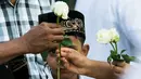 Umat Buddha Myanmar memberikan mawar putih kepada umat Islam yang akan melaksanakan salat Id pada perayaaan Idul Fitri di kota Than Lyin, pinggiran Yangon, Rabu (5/6/2019). Momen ini menjadi sebuah aksi solidaritas yang langka di sebuah negara, di mana Islam kerap difitnah.  (Sai Aung MAIN/AFP)