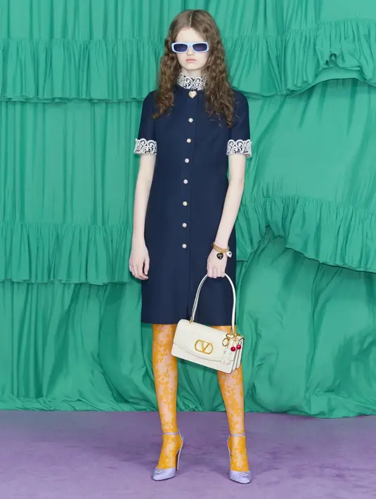 Koleksi Pre-Fall 2025, yang dipamerkan di showroom Milan, memadukan elemen era 70-an dan 80-an dengan sentuhan klasik. Potongan seperti blus pita, rok berumbai, gaun eyelet, rompi bordir ala hippie, hingga jaket suede berumbai tampil memukau.  [Dok/Valentino].