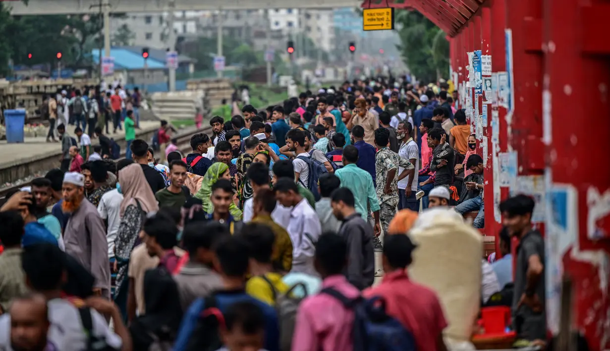 Orang-orang menunggu kereta api datang di stasiun Tongi saat mereka dalam perjalanan pulang menjelang Idul Adha, di Tongi di pinggiran Dhaka, Bangladesh, Jumat (14/6/2024). (MUNIR UZ ZAMAN / AFP)